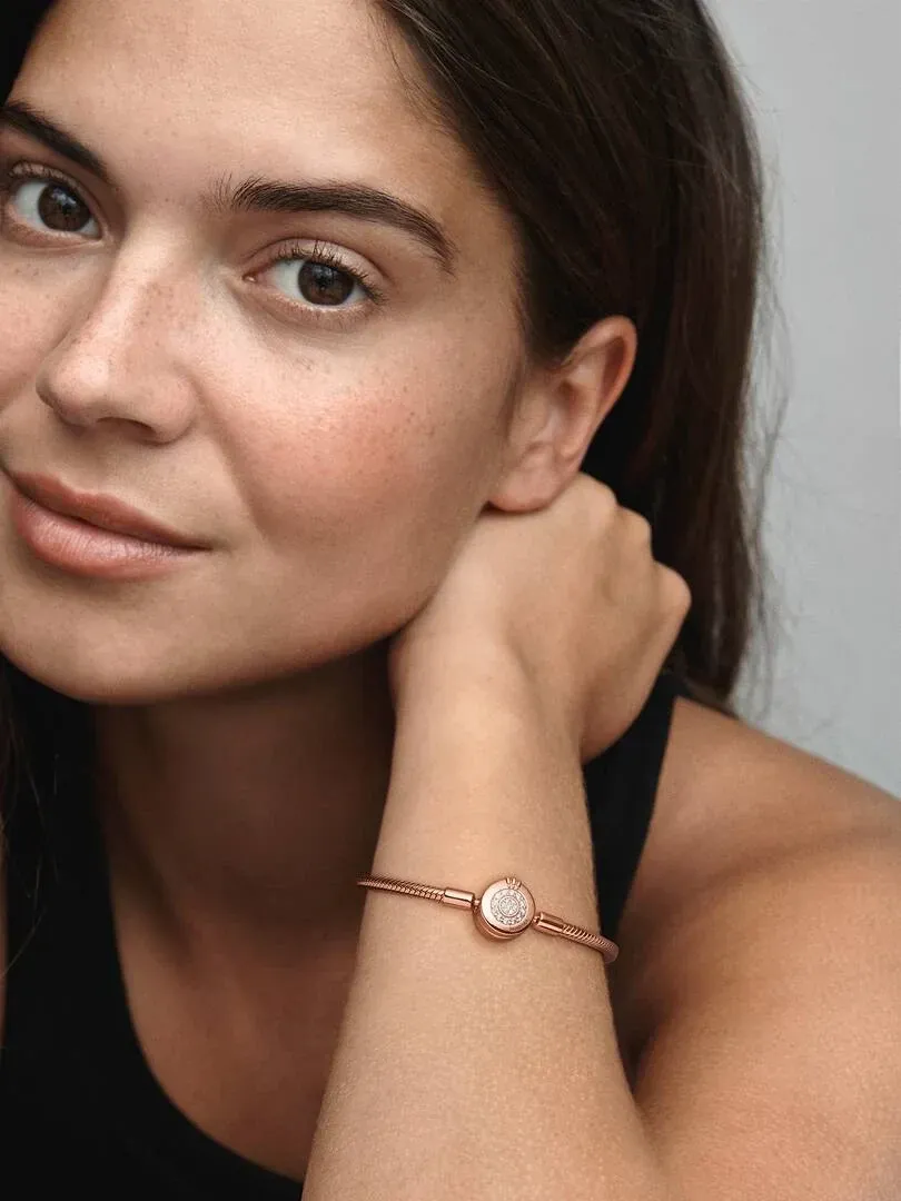 Close-up of the bracelet on a wrist, side view with model and blurred neutral background.