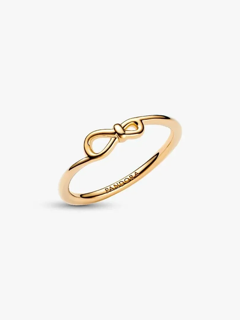 Anillo de nudo infinito visto en ángulo lateral, sobre fondo blanco puro.