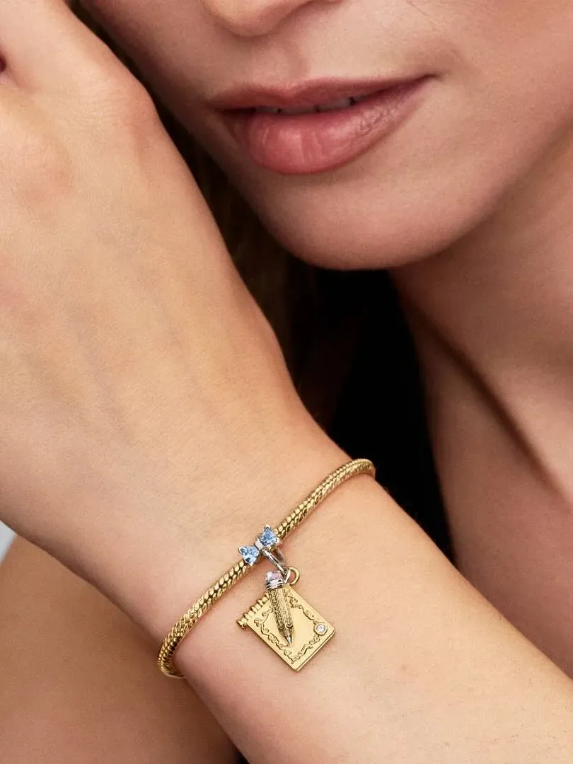 Nahaufnahme des Tanzkarten-Charms am Handgelenk, Seitenansicht mit unscharfem Hintergrund.