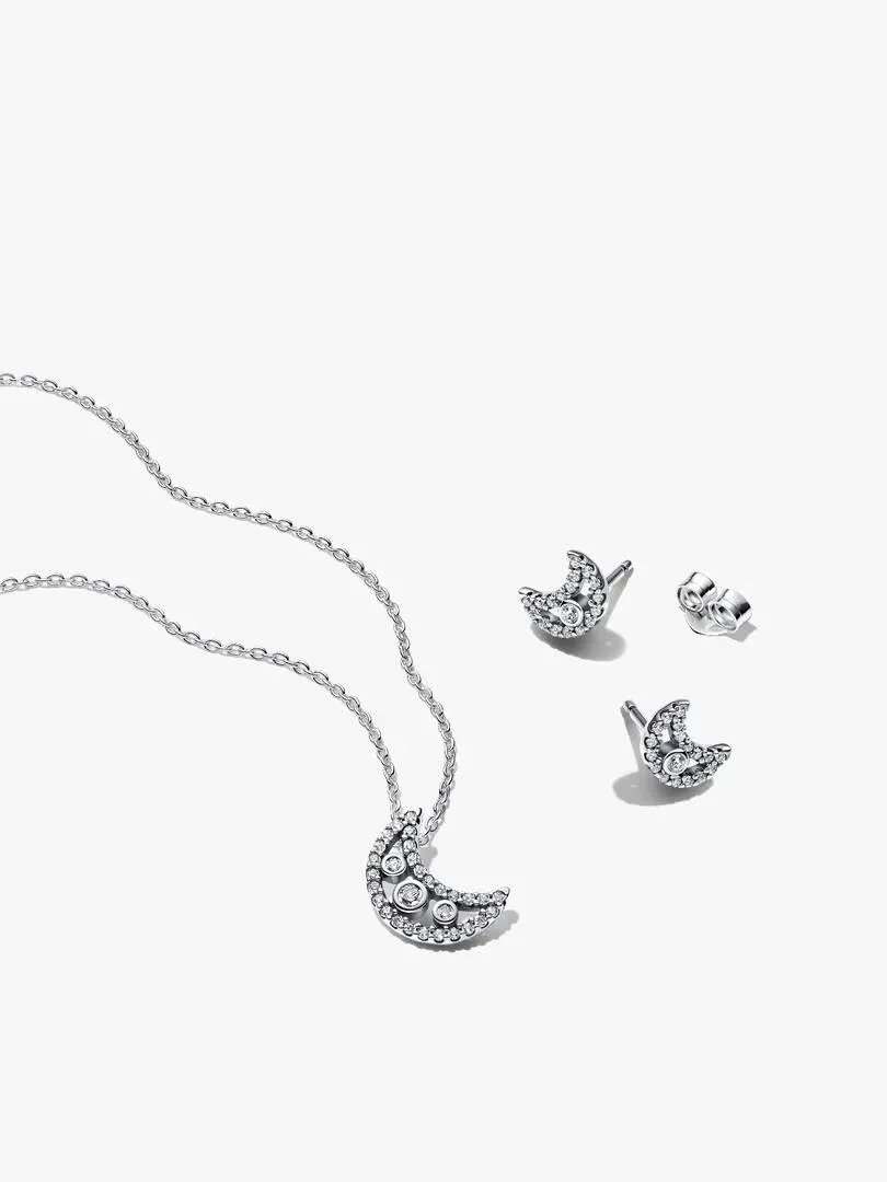 Conjunto de collar y pendientes de luna en plata sobre fondo blanco, vista cenital con disposición diagonal.