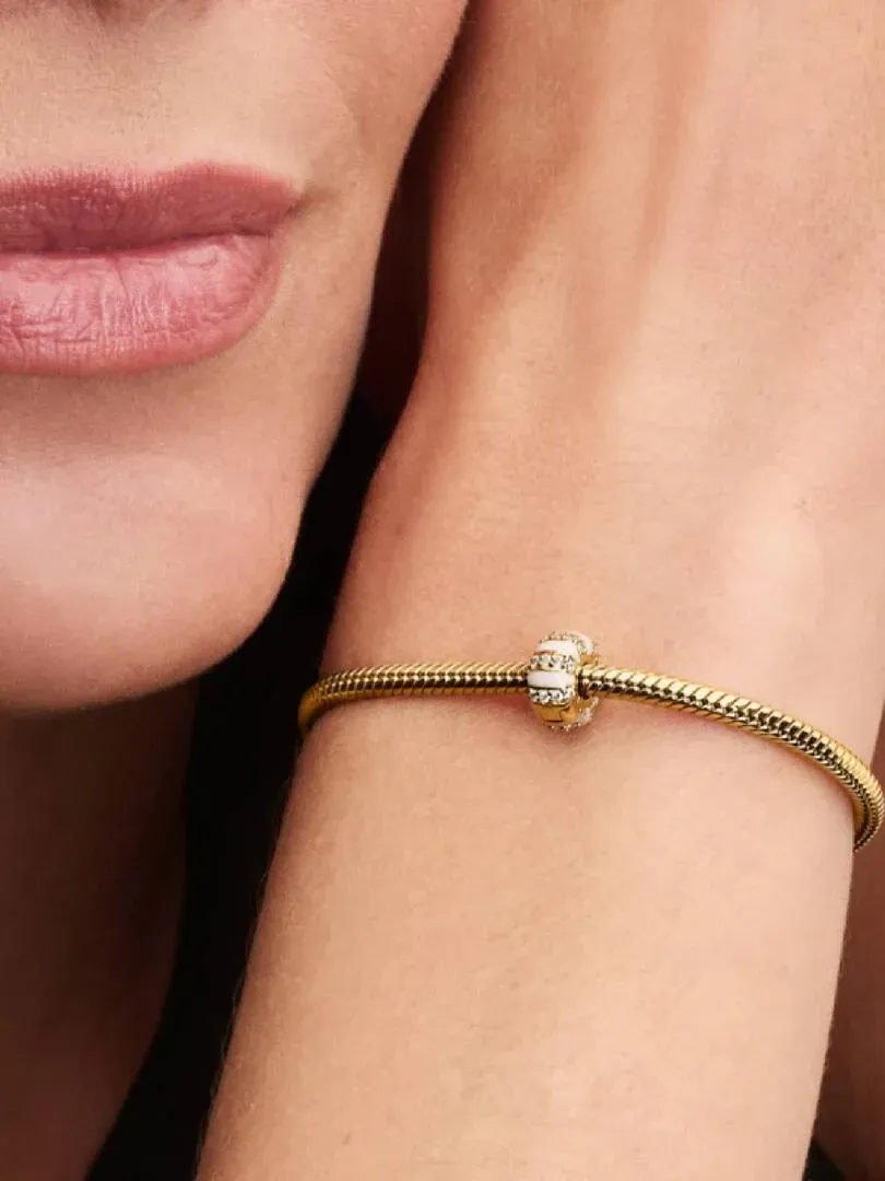 Close-up van de clip charm om een pols, zijaanzicht met een wazig gezicht op de achtergrond.