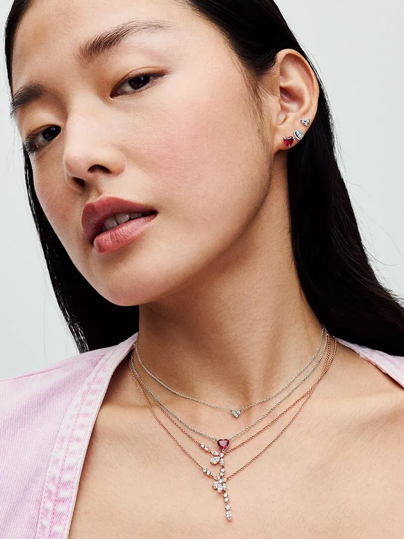 Primer plano de modelo luciendo collares de capas con gemas, toma lateral enfocada en el cuello y la oreja.