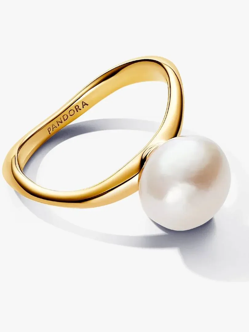 Anillo de perla barroca visto desde un ángulo lateral, banda dorada ondulada sobre fondo blanco.