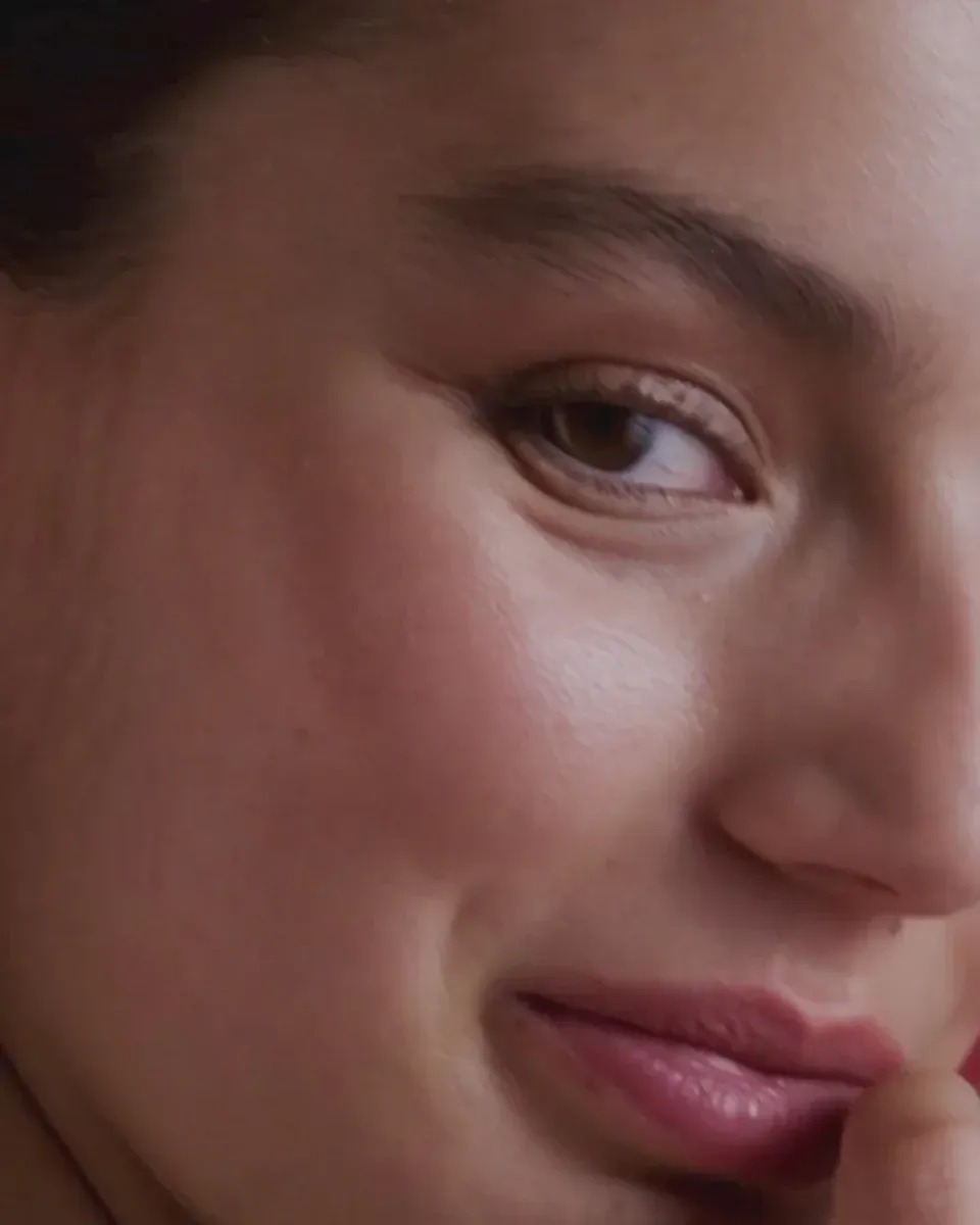 Side close-up of a model's face, focusing on the ear and jawline area.