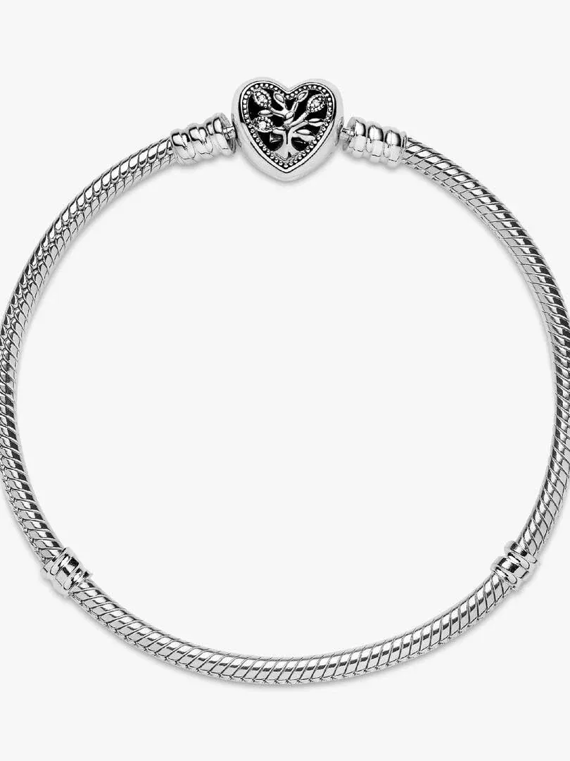 Vista frontal de la pulsera circular sobre fondo blanco, destacando el cierre de corazón con diseño de árbol.