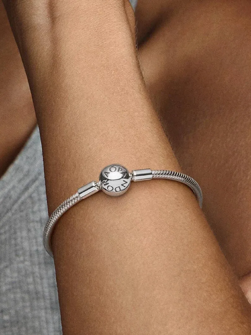 Primer plano de la pulsera de cadena de serpiente puesta en la muñeca, toma lateral con fondo desenfocado.