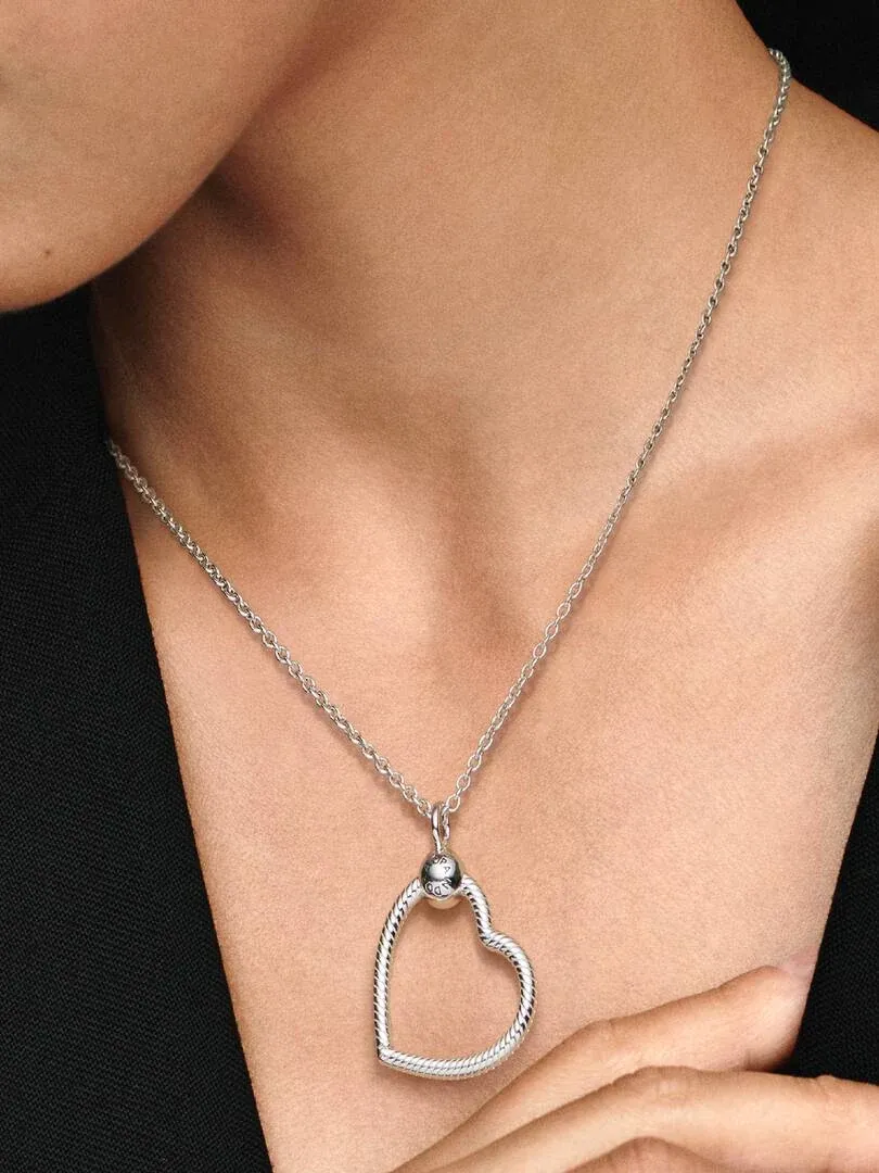 Close-up of the silver heart pendant on a model's neck and chest, front view.
