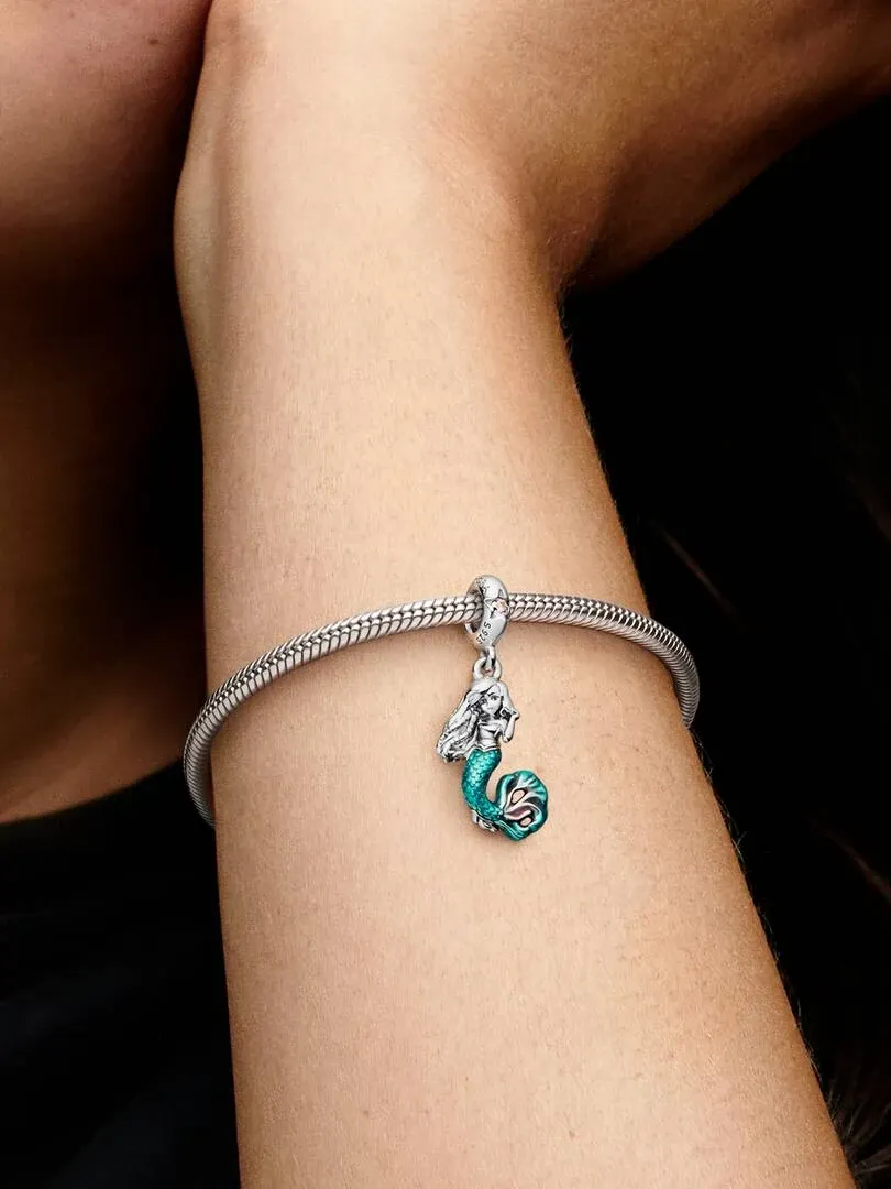 Charm de sirena con esmalte turquesa en pulsera de plata, toma lateral sobre la muñeca.