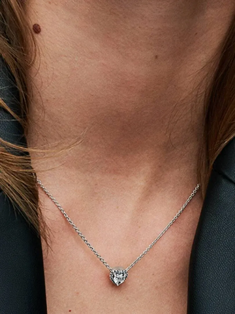 Gros plan du collier avec pendentif cœur porté sur le cou d'un mannequin, vue de face.