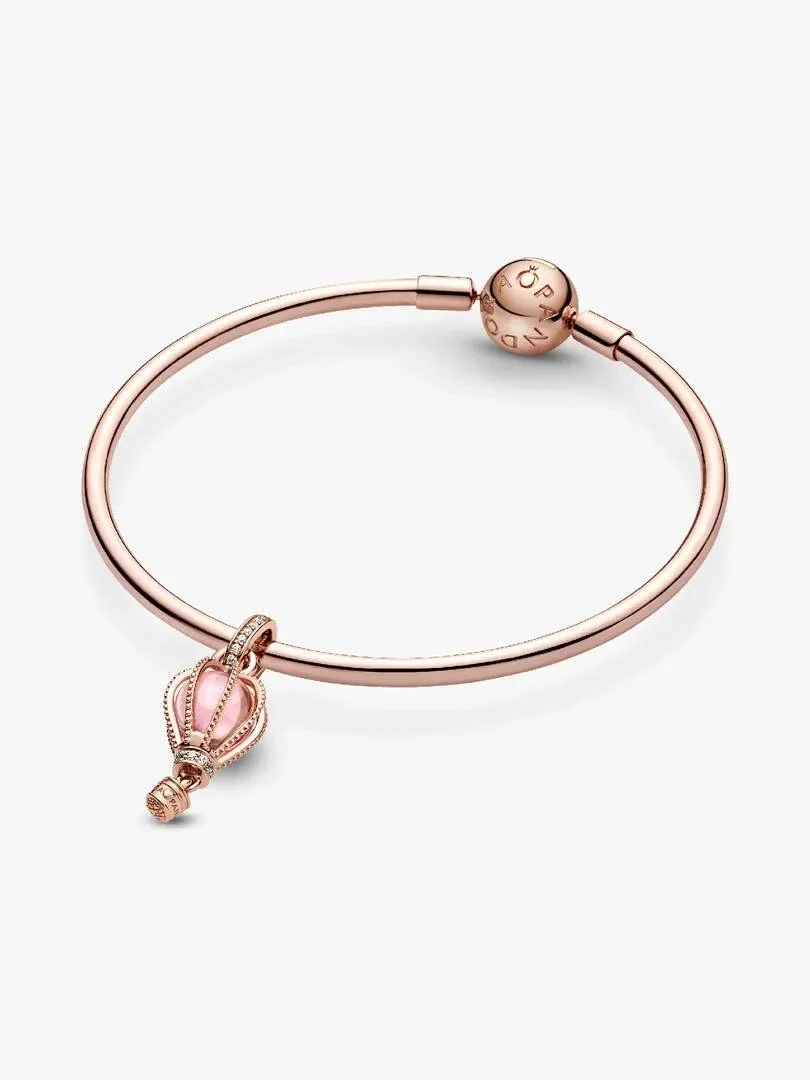 Rose gold bangle with hot air balloon charm, side angle view on a white background.