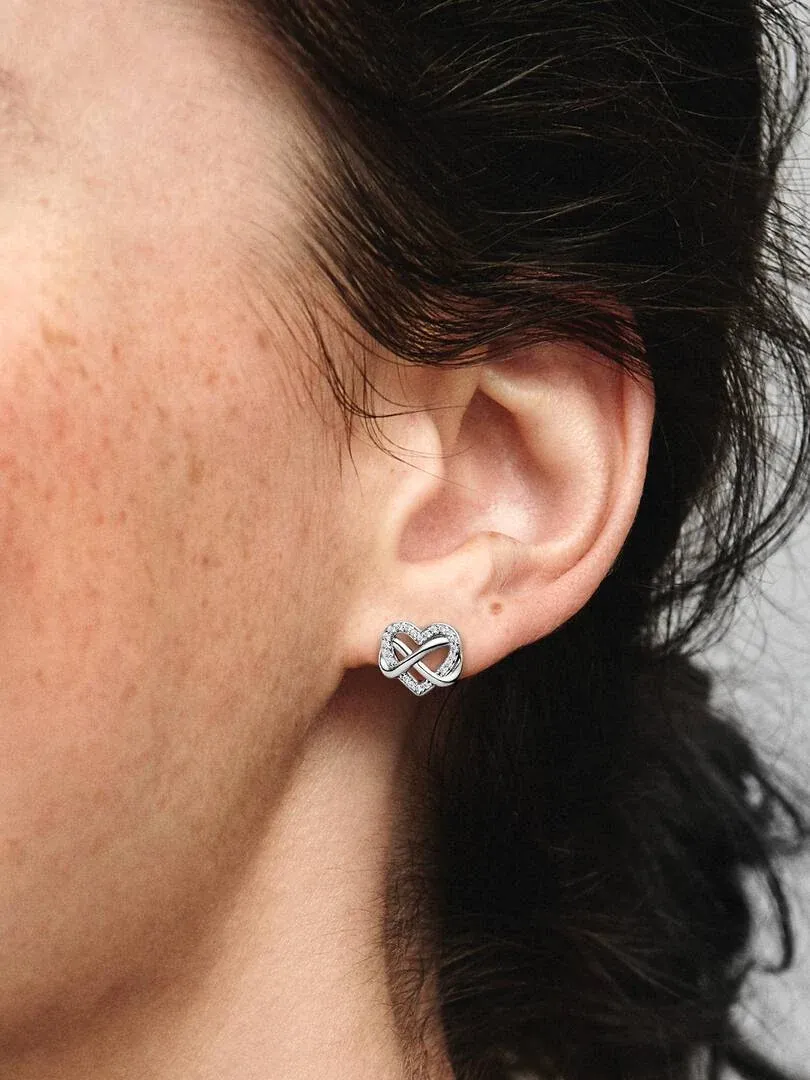 Gros plan latéral d'une boucle d'oreille puces sur l'oreille, peau tachetée et cheveux noirs.