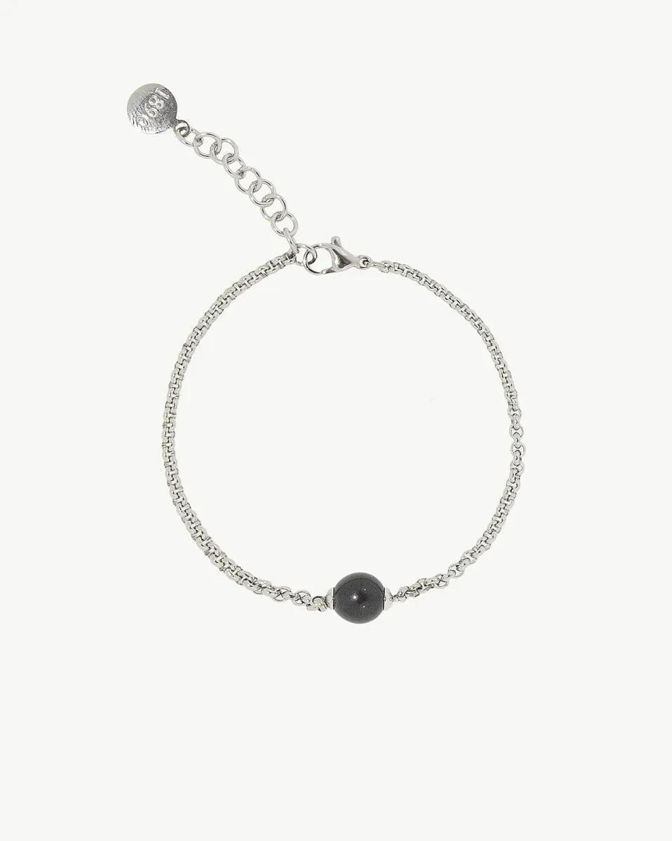 Link bracelet with black pearl, front view on white background, top-down shot.