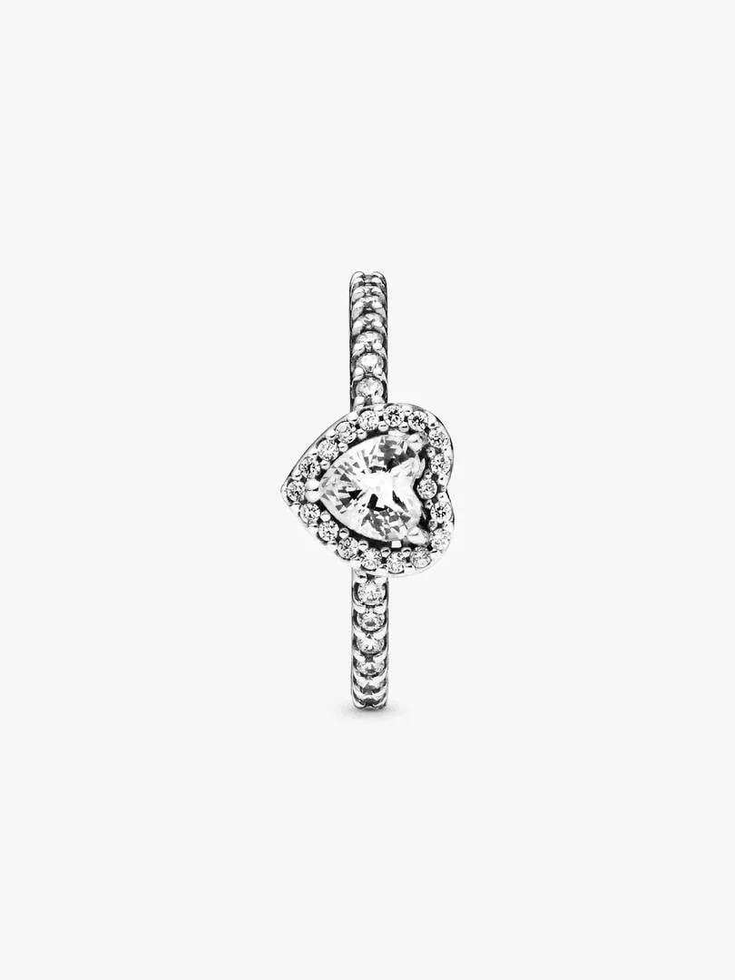 Anillo de corazón visto en ángulo lateral, fondo blanco, detalle del engaste y la circonita central.