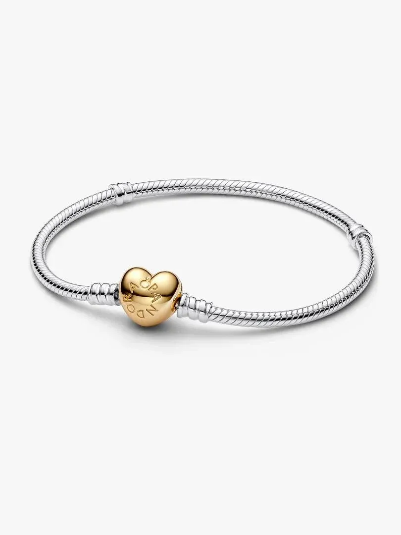 Pulsera de cadena vista desde un ángulo lateral, fondo blanco, detalle del cierre en forma de corazón dorado.