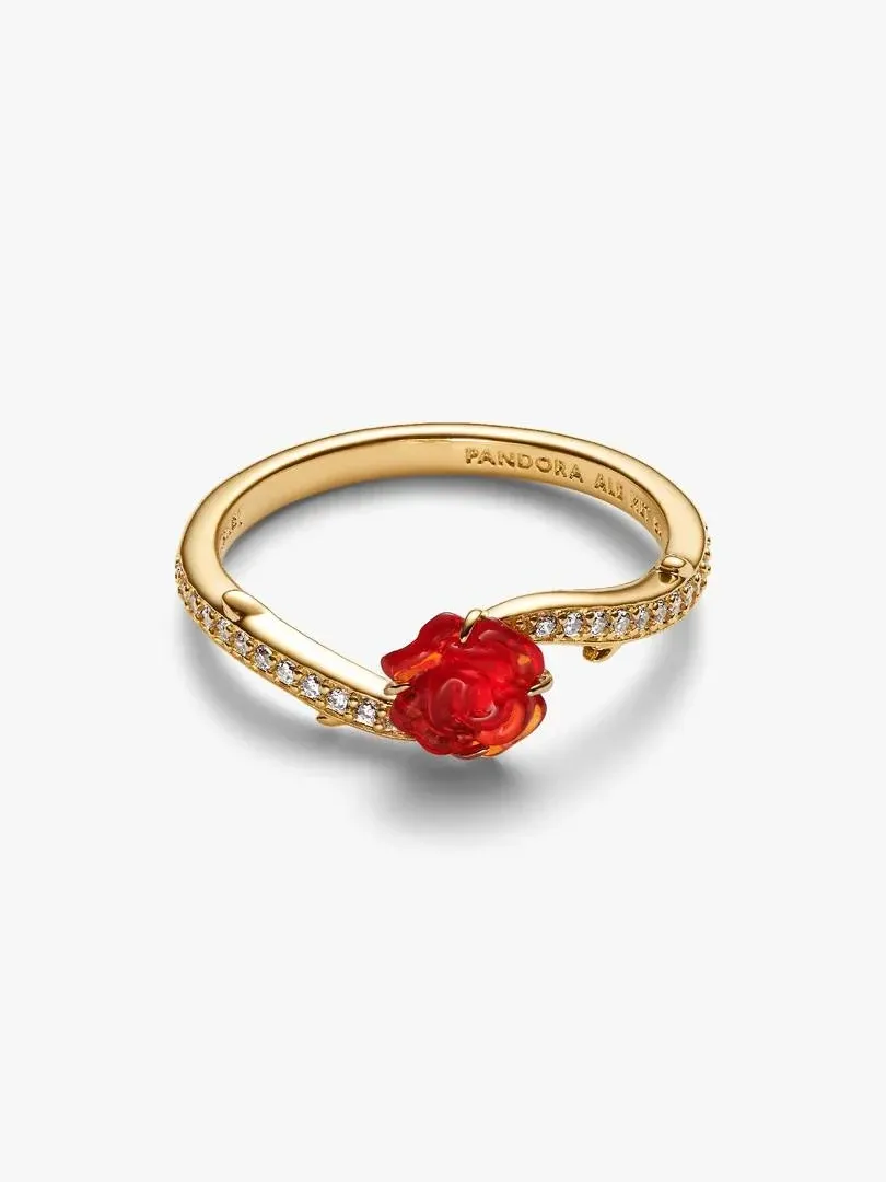 Anillo de oro con rosa roja central, vista en ángulo tres cuartos sobre fondo blanco.