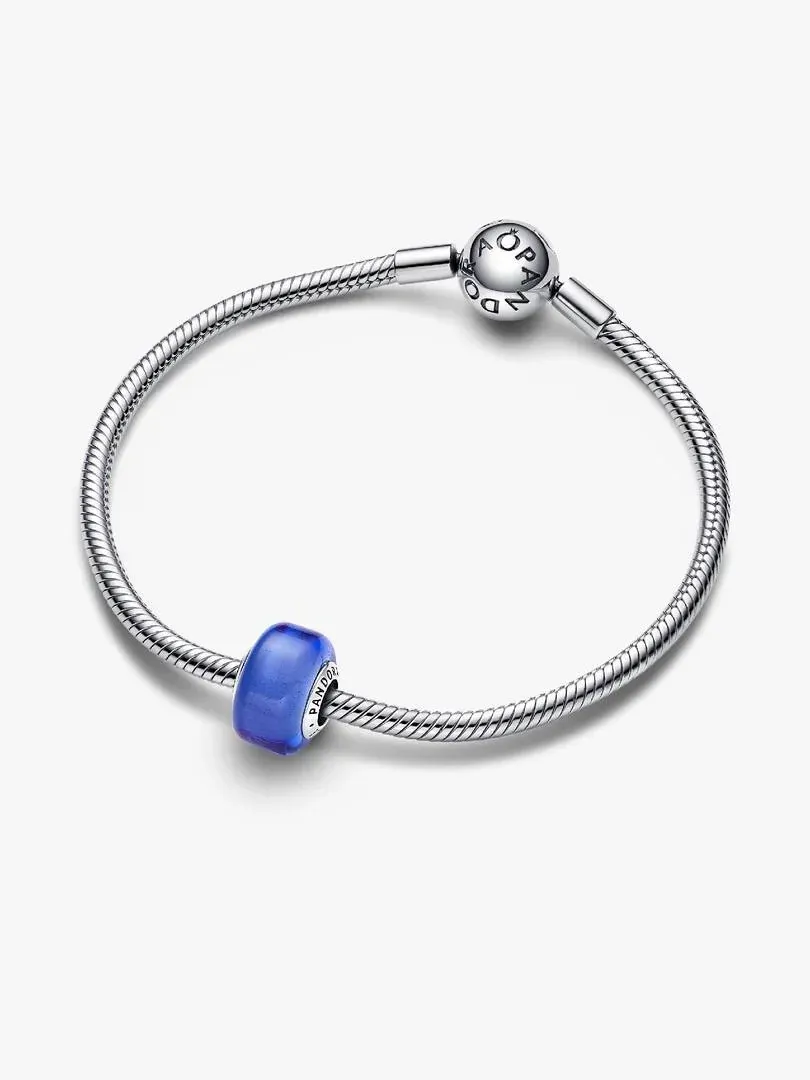 Pulsera de plata con charm azul visto desde un ángulo superior, fondo blanco neutro.