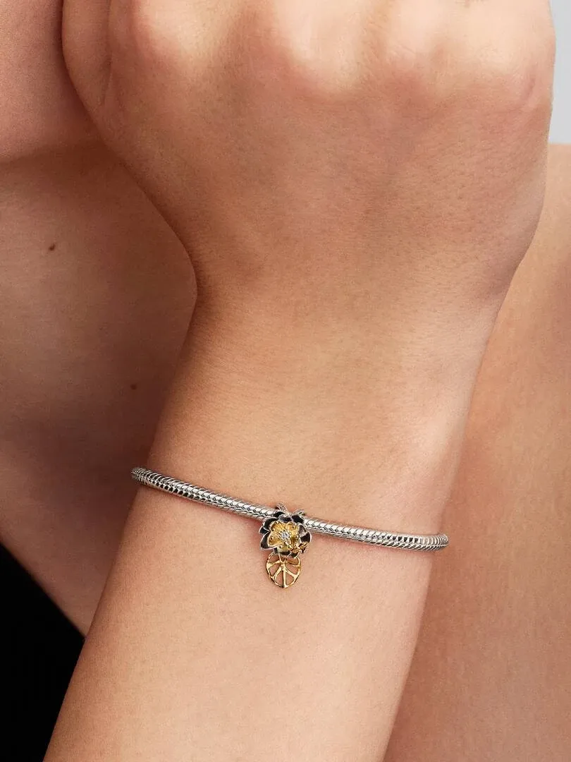 Primer plano del charm de flor en una muñeca, toma lateral con fondo suave y desenfocado.