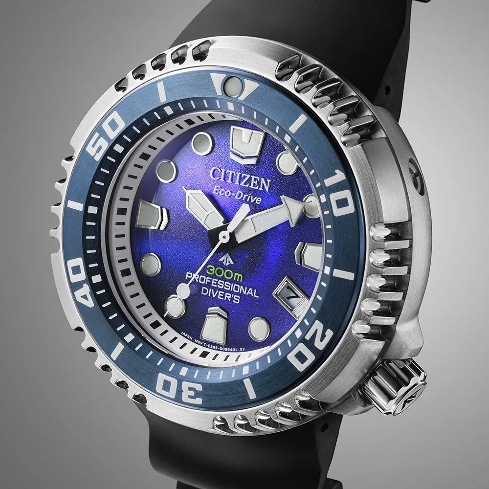 Primer plano en ángulo del dial azul y el bisel plateado sobre fondo gris neutro