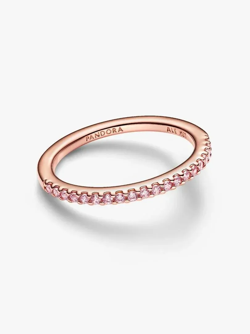 Anillo de banda visto en ángulo lateral sobre fondo blanco, mostrando el engaste pavé de circonitas rosas.