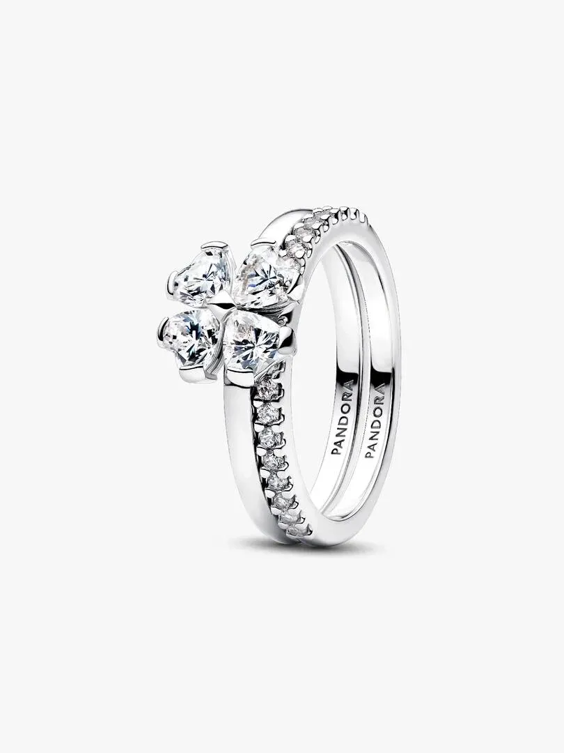 Side view of two interlocking sterling silver rings with heart-shaped stones, white background.