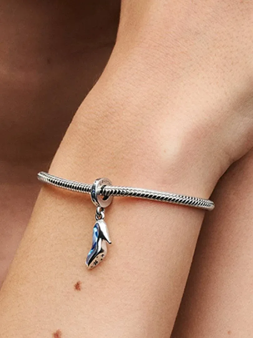 Gros plan du charm chaussure sur un bracelet, vue latérale sur un poignet.