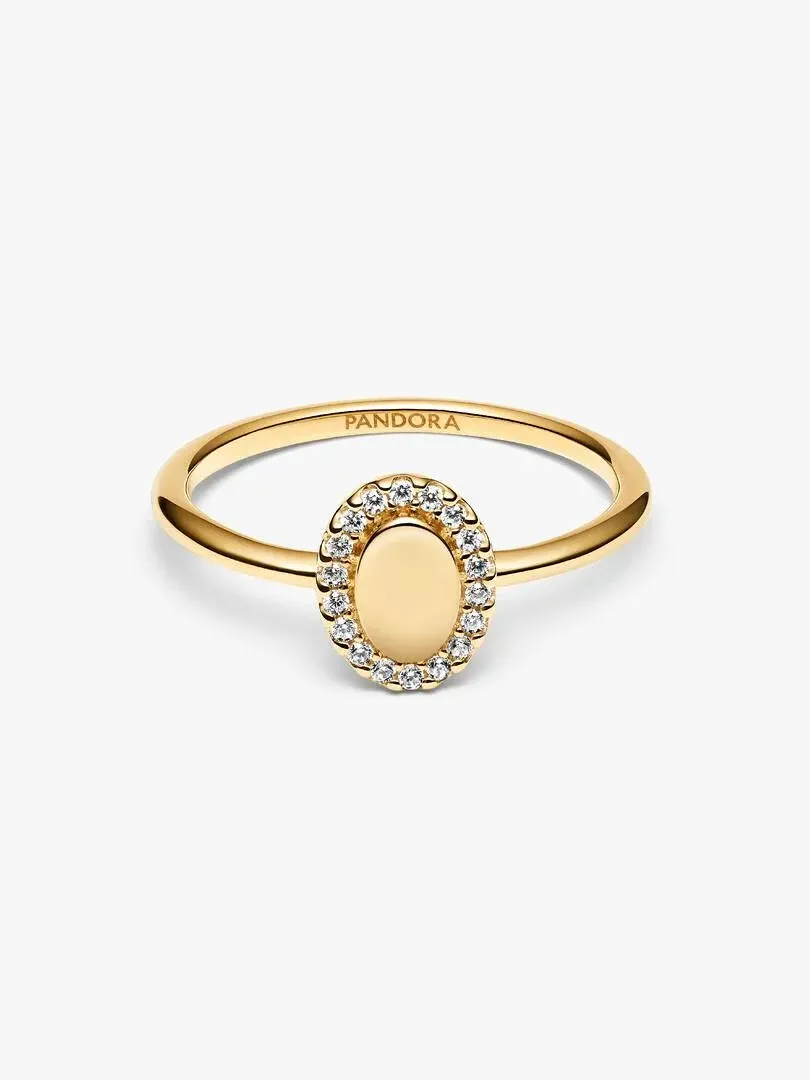 Anillo de oro con piedra ovalada y halo de circonitas, vista frontal en ángulo sobre fondo blanco.