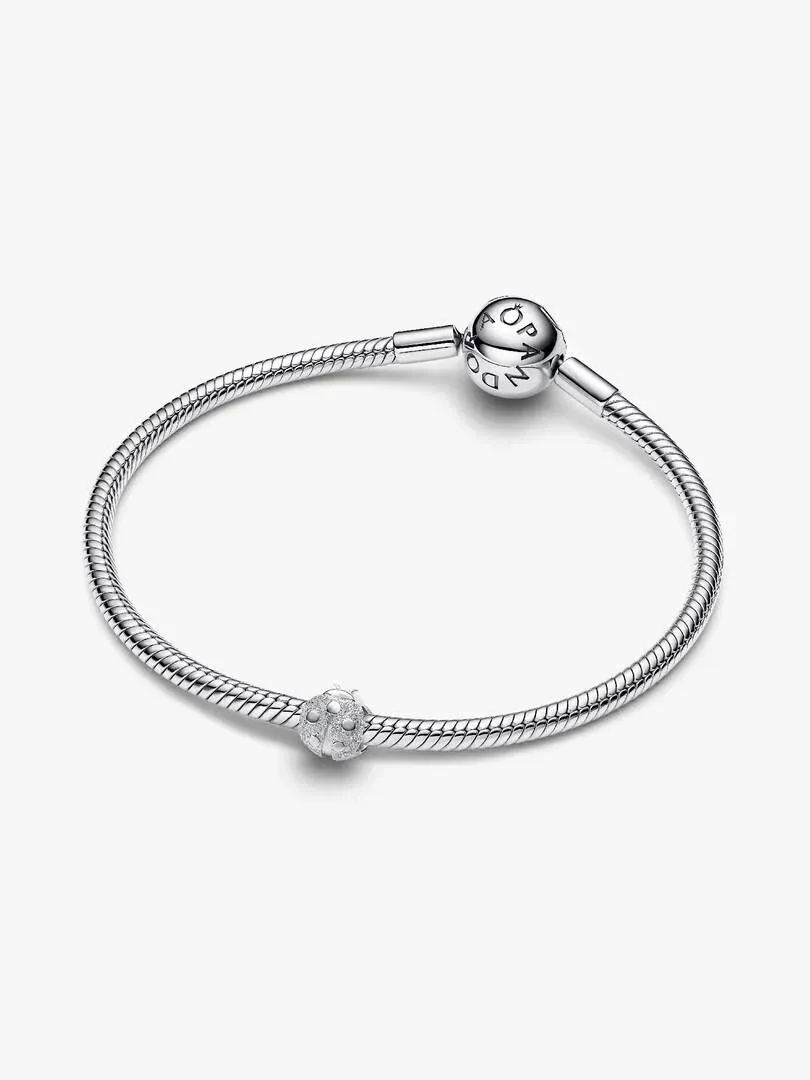 Zilveren armband met lieveheersbeestjes charm, vooraanzicht onder een hoek op witte achtergrond.