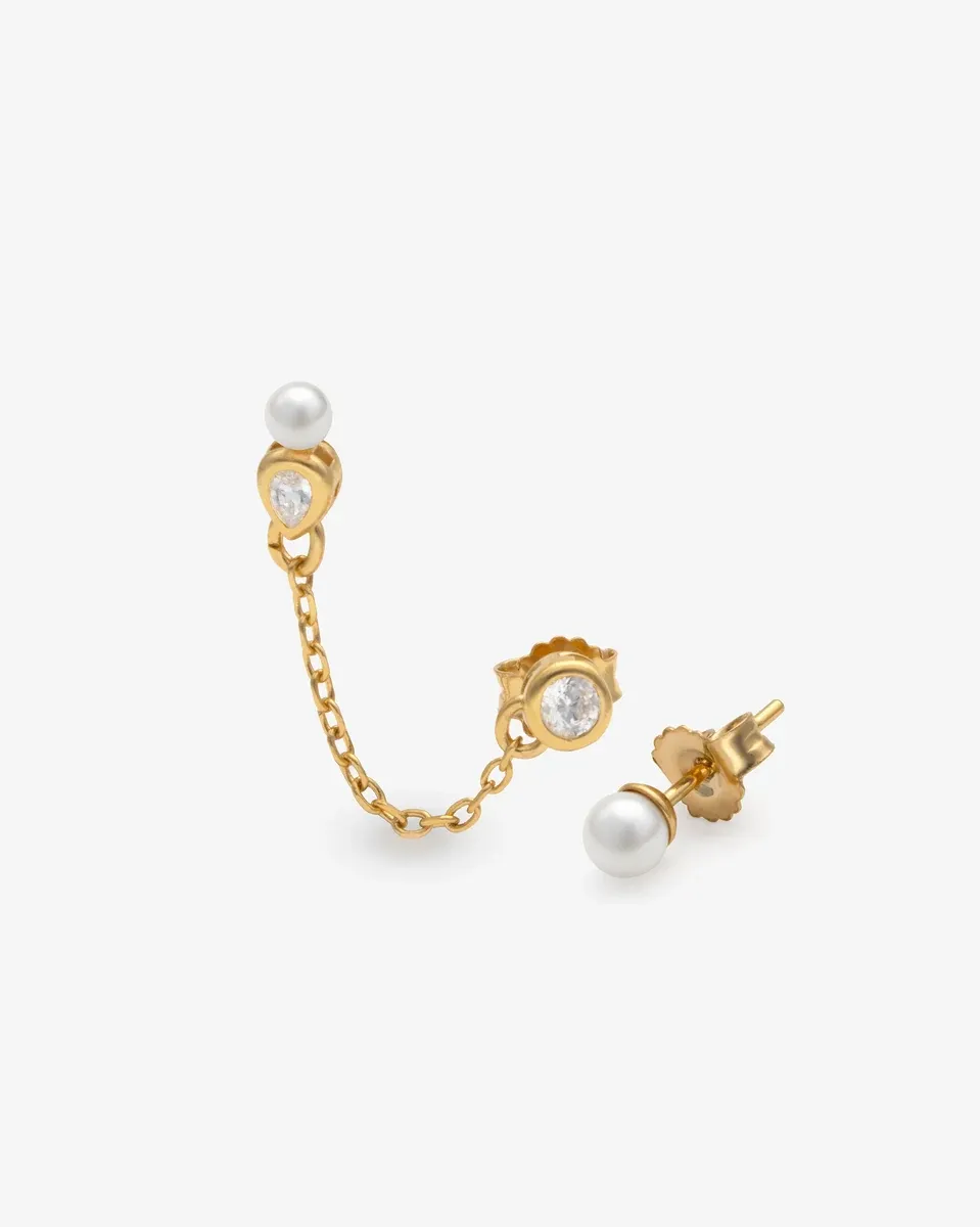 Vooraanzicht van asymmetrische oorbellen met parels en ketting, op een witte achtergrond.