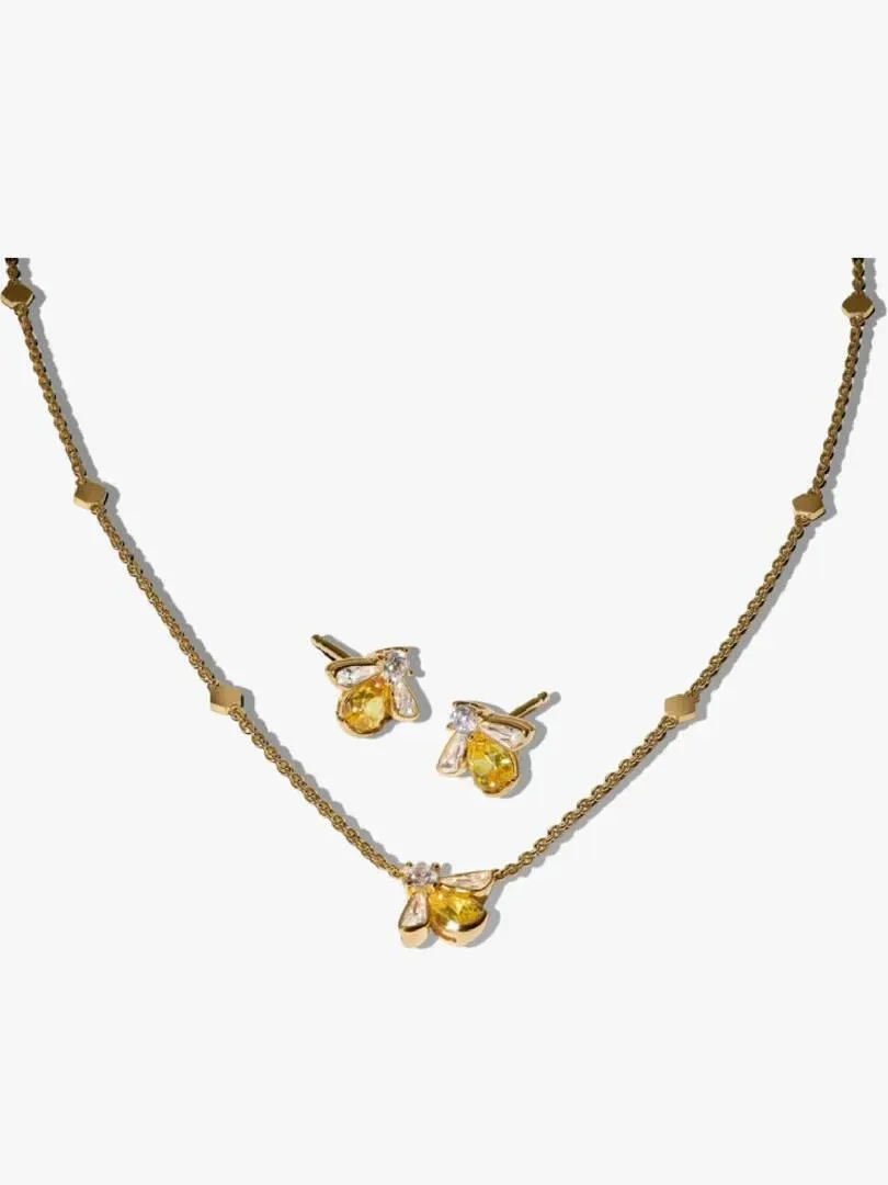 Conjunto de collar y pendientes de abeja sobre fondo blanco, vista frontal con cadena dispuesta en arco.