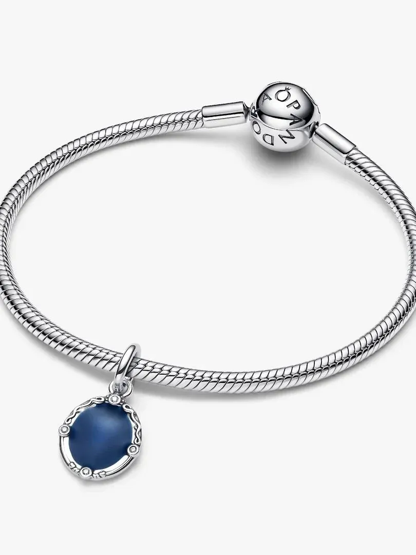 Charm circular con esmalte azul en pulsera de plata, vista frontal sobre fondo blanco.