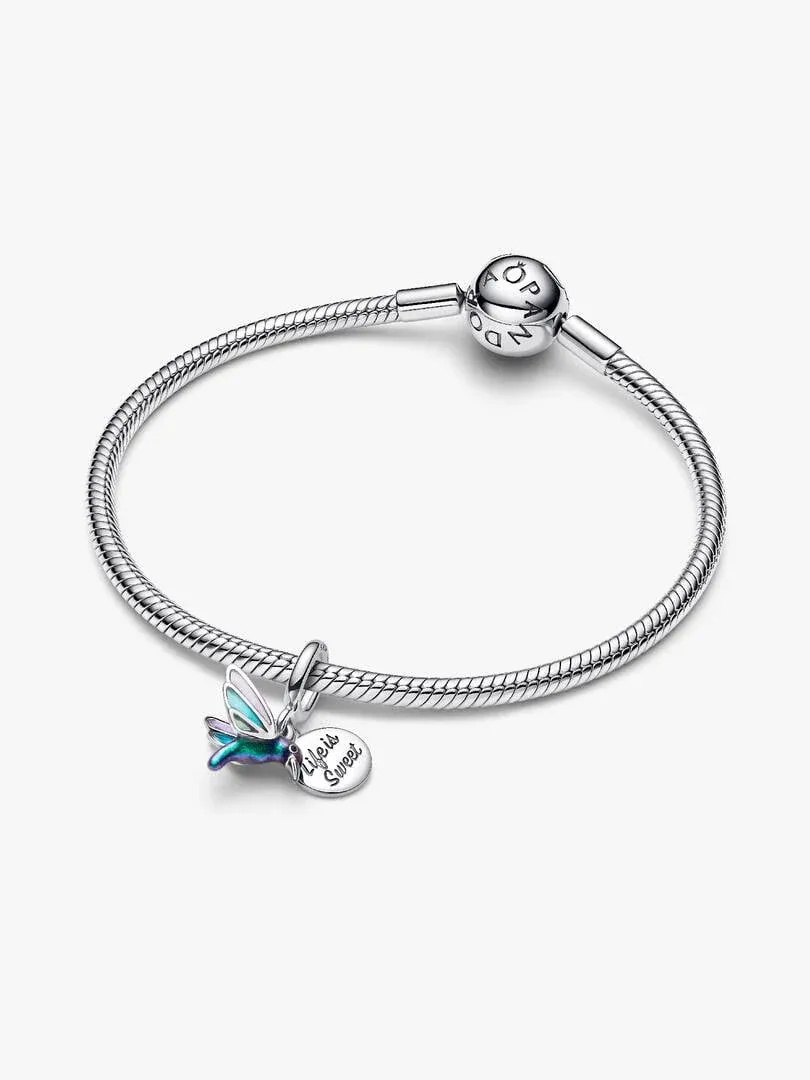 Pulsera de plata con charm de colibrí, vista lateral sobre fondo blanco, enfoque en el colgante esmaltado.