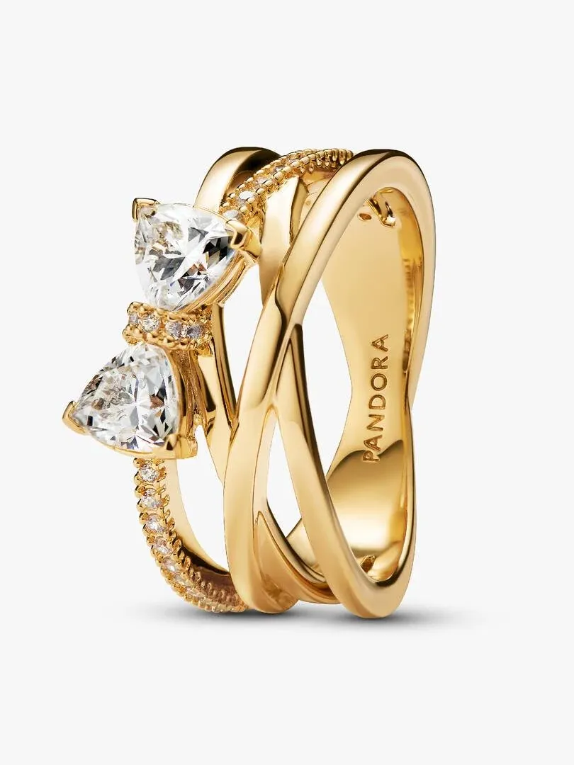 Anillo de bandas cruzadas con circonitas, vista lateral en ángulo sobre fondo blanco.