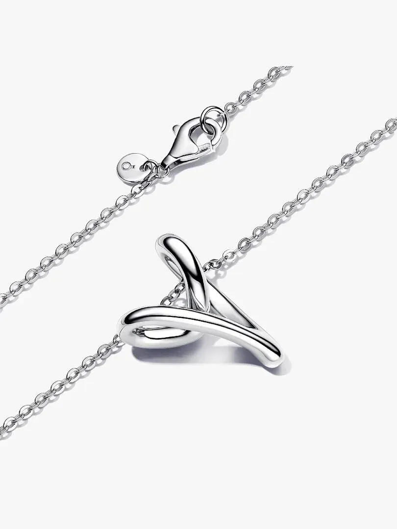 Close-up of the organic silver heart pendant on a white background, diagonal shot focusing on metal texture.