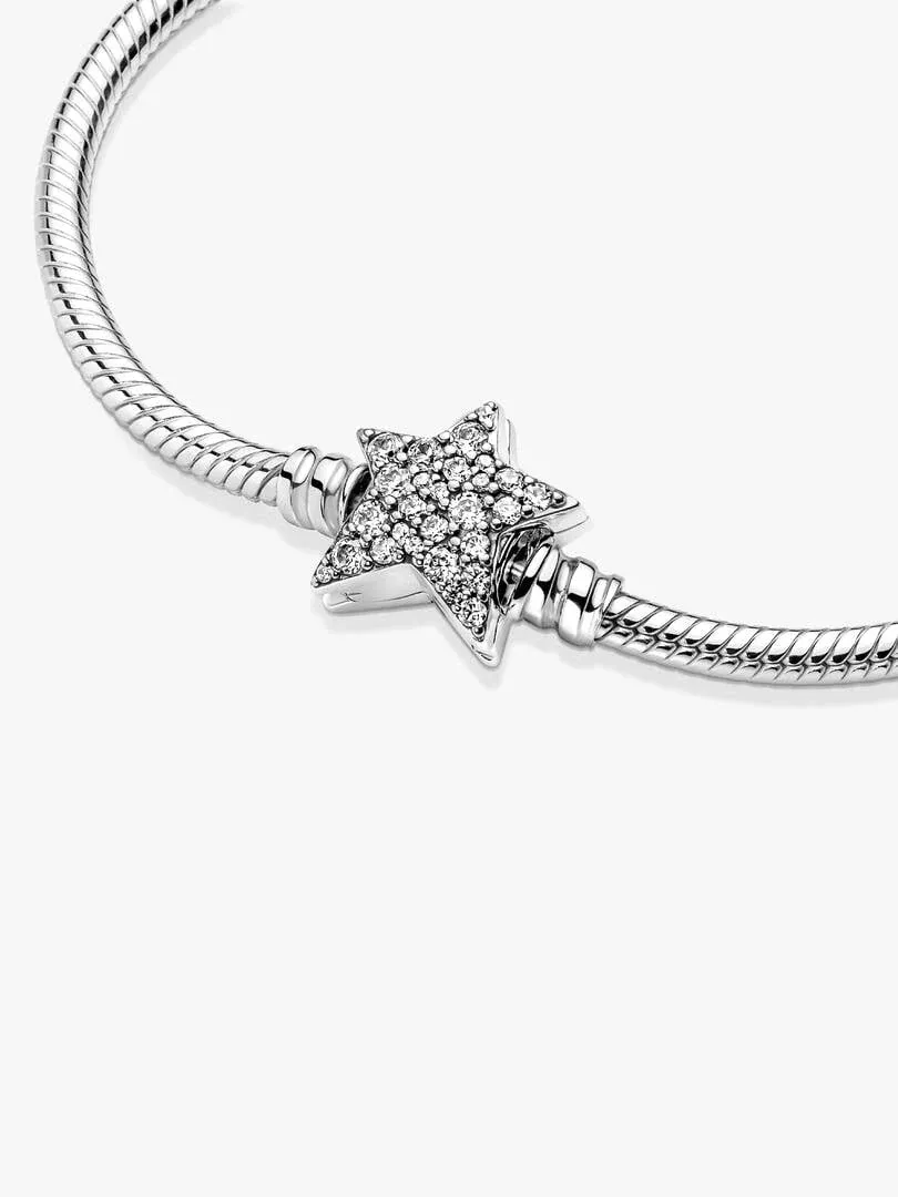 Primer plano del cierre de estrella con circonitas, sobre cadena de serpiente, fondo blanco.