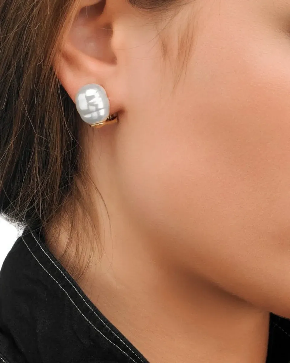 Seitenansicht Nahaufnahme eines Barockperlen-Ohrrings am Ohr, vor weichem Hauthintergrund.