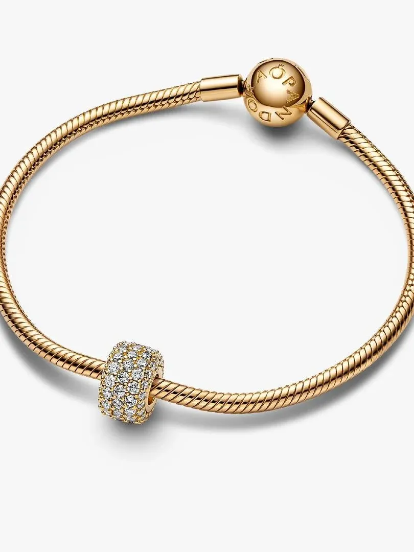 Gouden slangket armband met pavé charm, bovenaanzicht op een witte achtergrond.