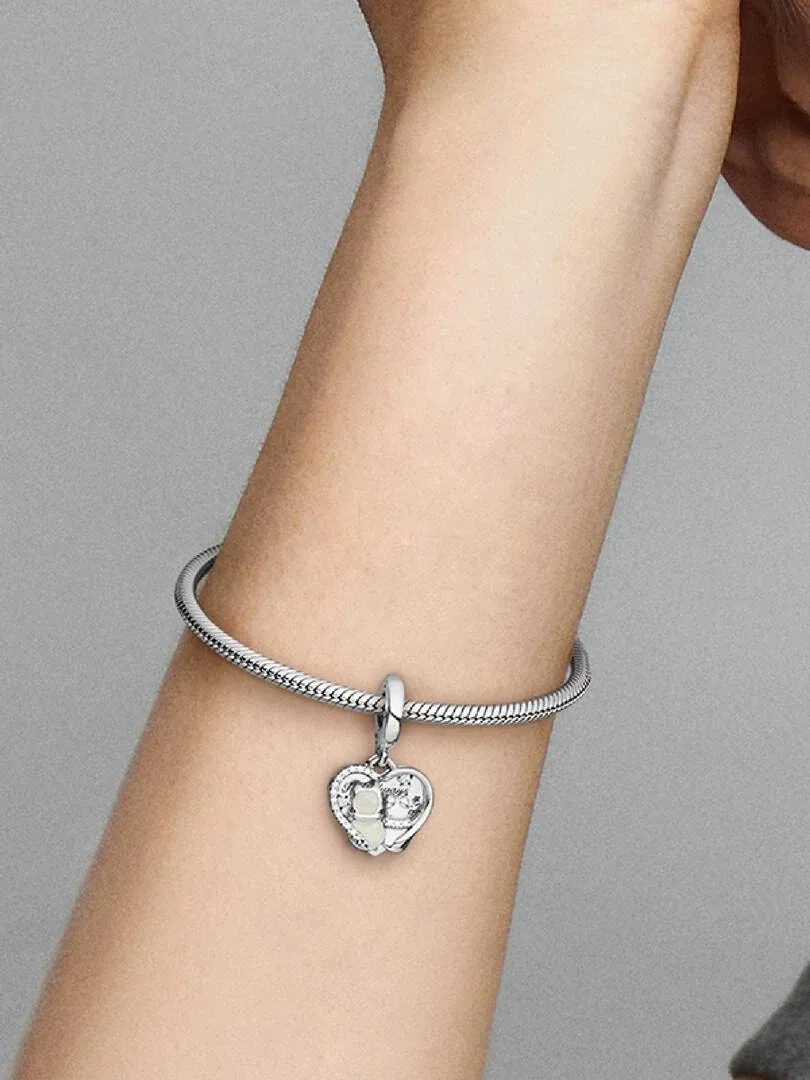 Close-up of a wrist wearing a bracelet with cat charm, side view against a neutral gray background.