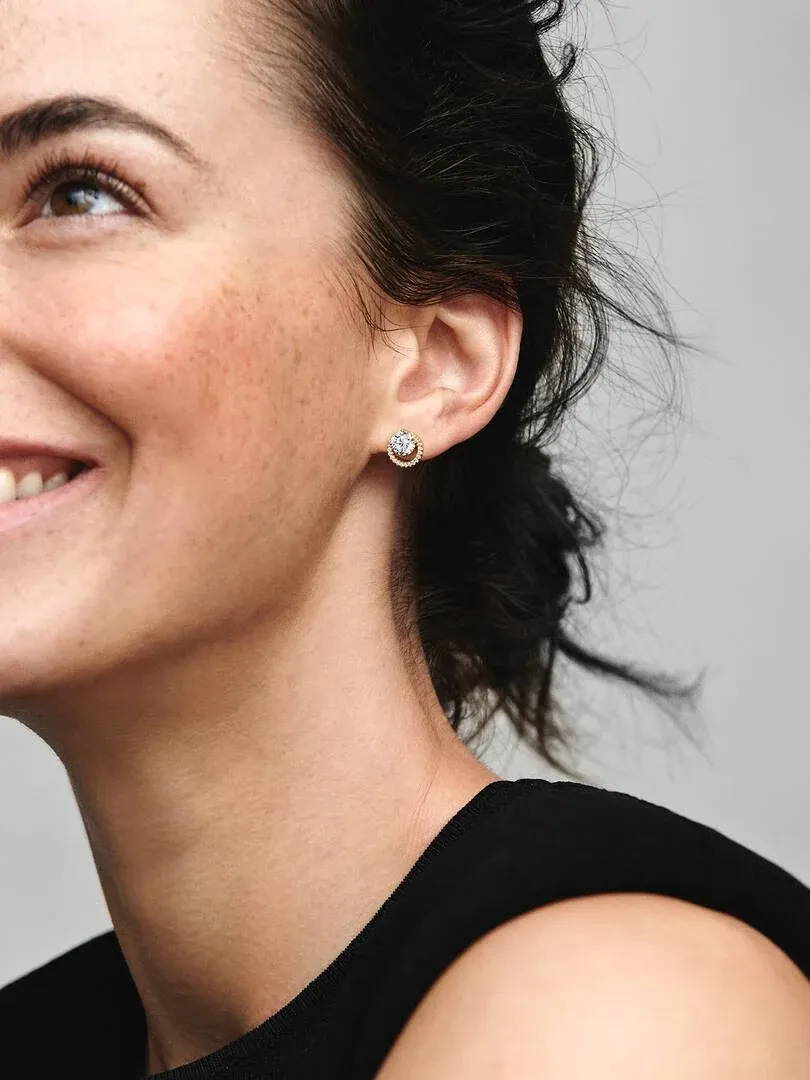 Nahaufnahme eines Halo-Steckohrrings am Ohrläppchen, Seitenprofil eines Models.