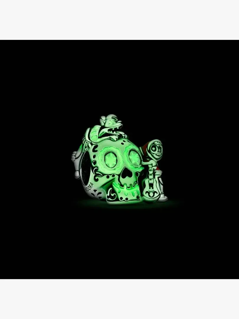 Charm de calavera con detalles esmaltados en verde brillante sobre fondo negro, vista lateral tres cuartos.