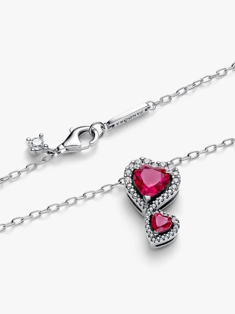 Close-up of the red heart pendants and silver clasp on a white background.