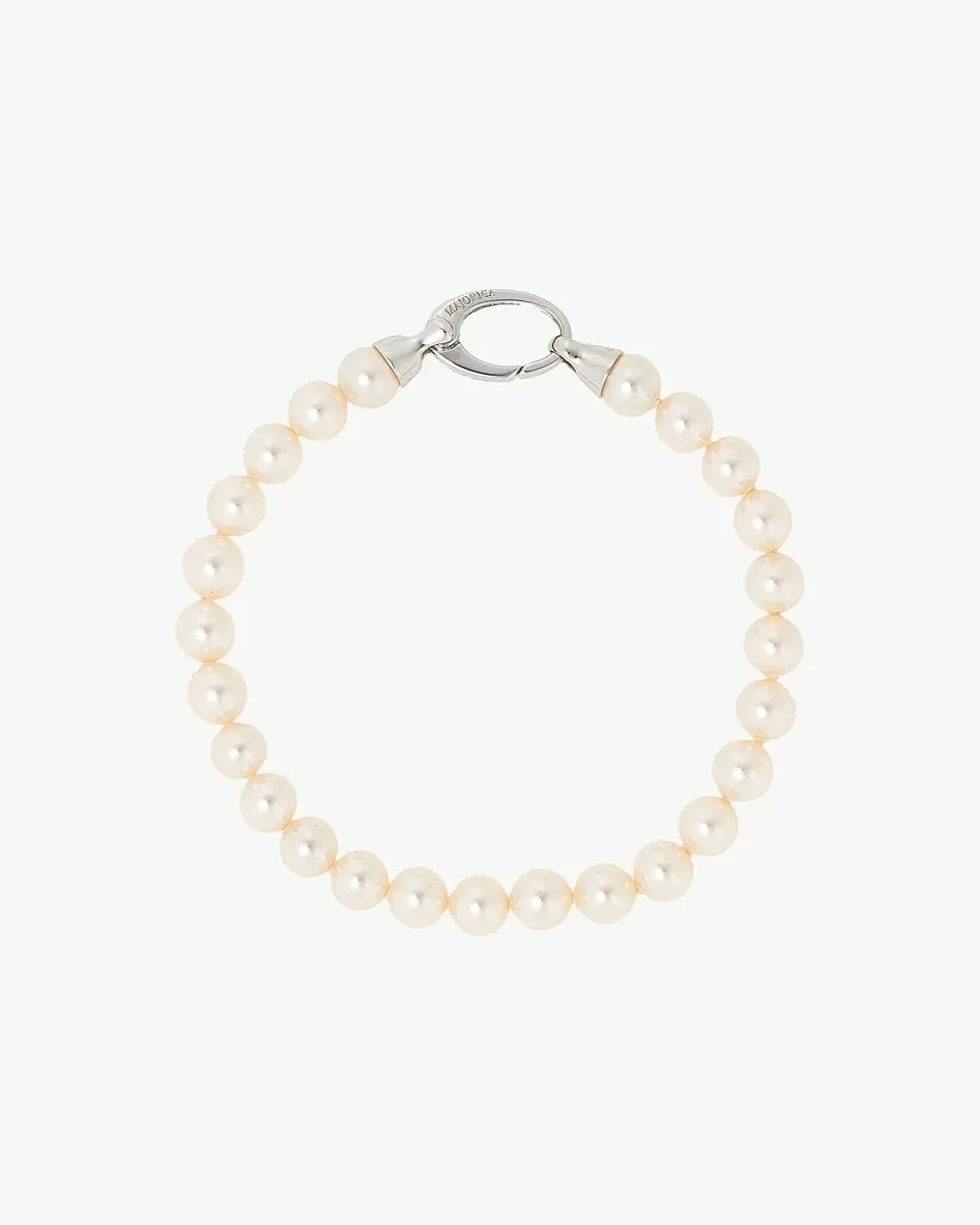 Pearl bracelet arranged in a circle on a white background, top view showing the silver clasp detail.