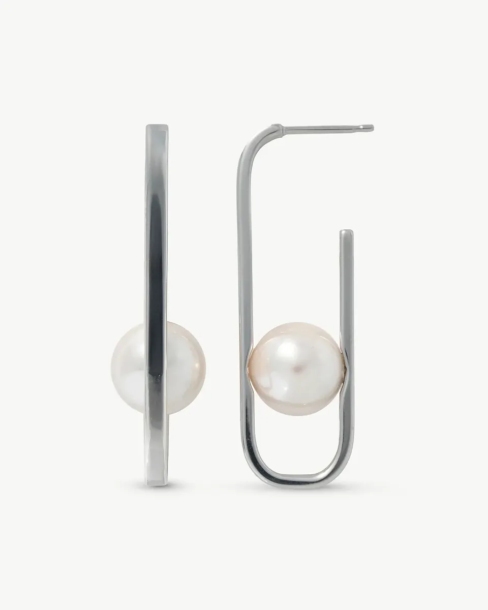 Vista frontal y de perfil de pendientes de perla blanca con estructura ovalada de plata sobre fondo blanco.