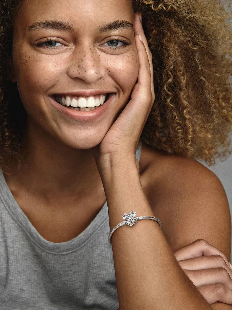 Nahaufnahme des Armbands am Handgelenk eines lächelnden Modells, Seitenansicht mit unscharfem Hintergrund.