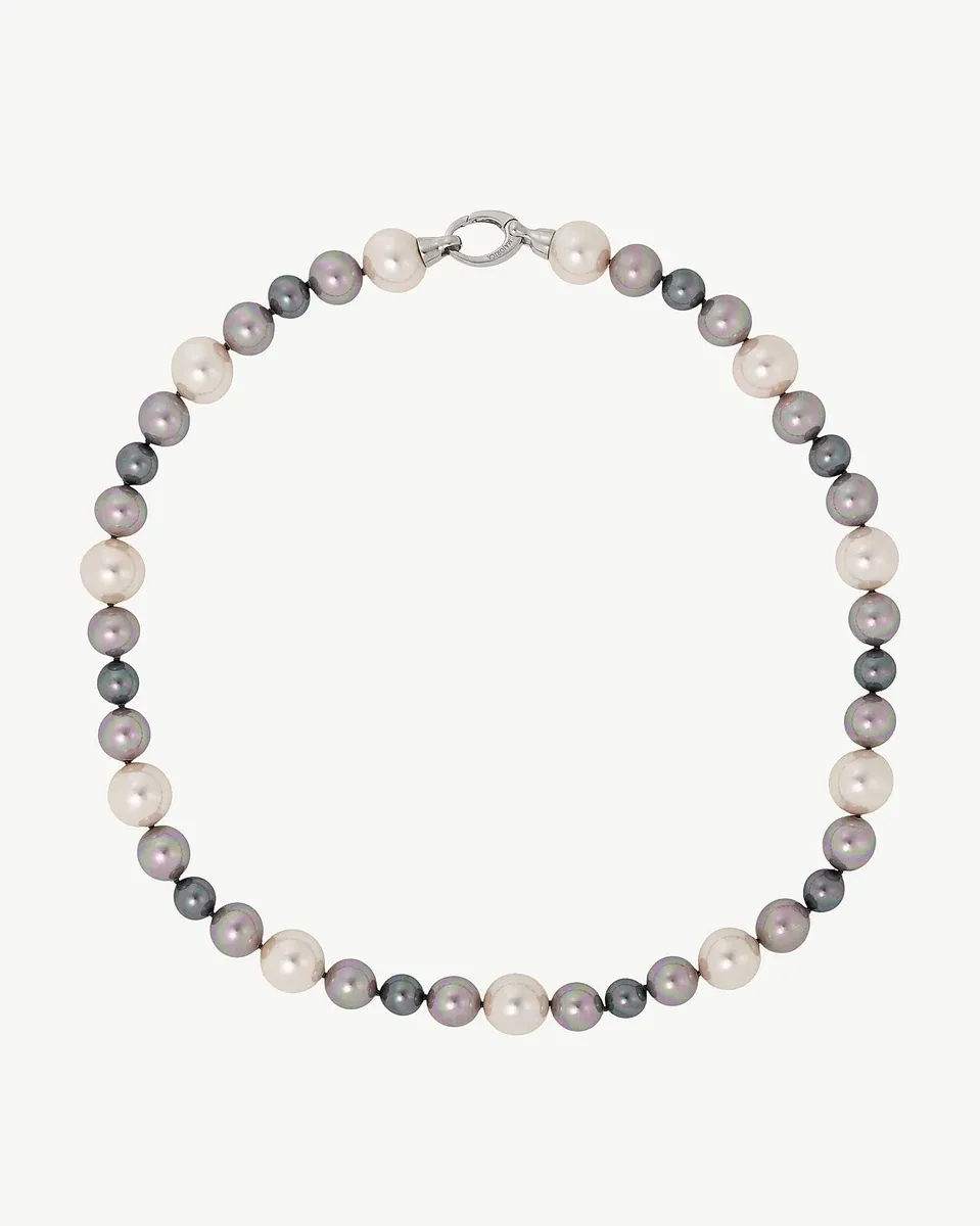 Collar de perlas dispuesto en círculo sobre fondo blanco, vista frontal cenital.