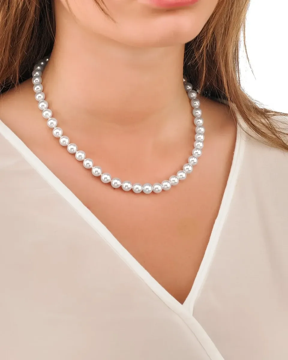 Close-up van het collier om de hals van een model, vooraanzicht op een wit kledingstuk.