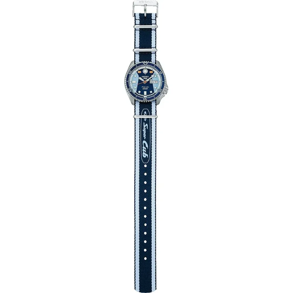 Full view of the watch displayed vertically on white background, detail of the dial and striped fabric strap