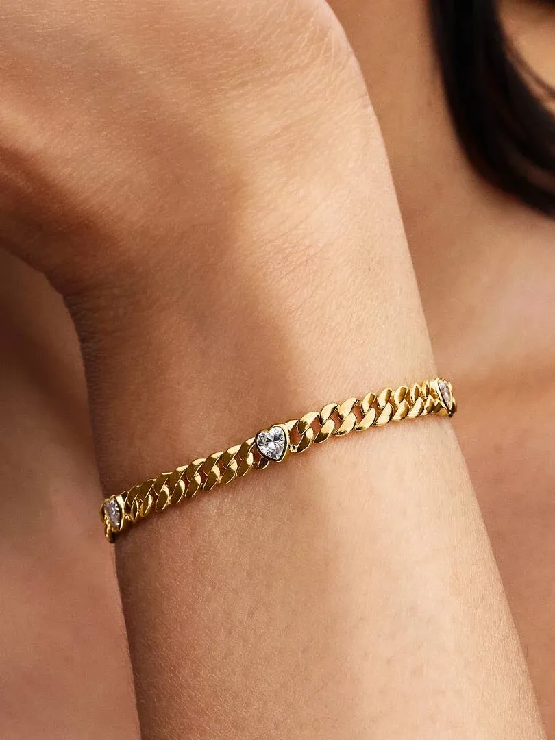 Close-up of the Cuban link bracelet on a wrist, side view focusing on the heart-shaped stone detail.