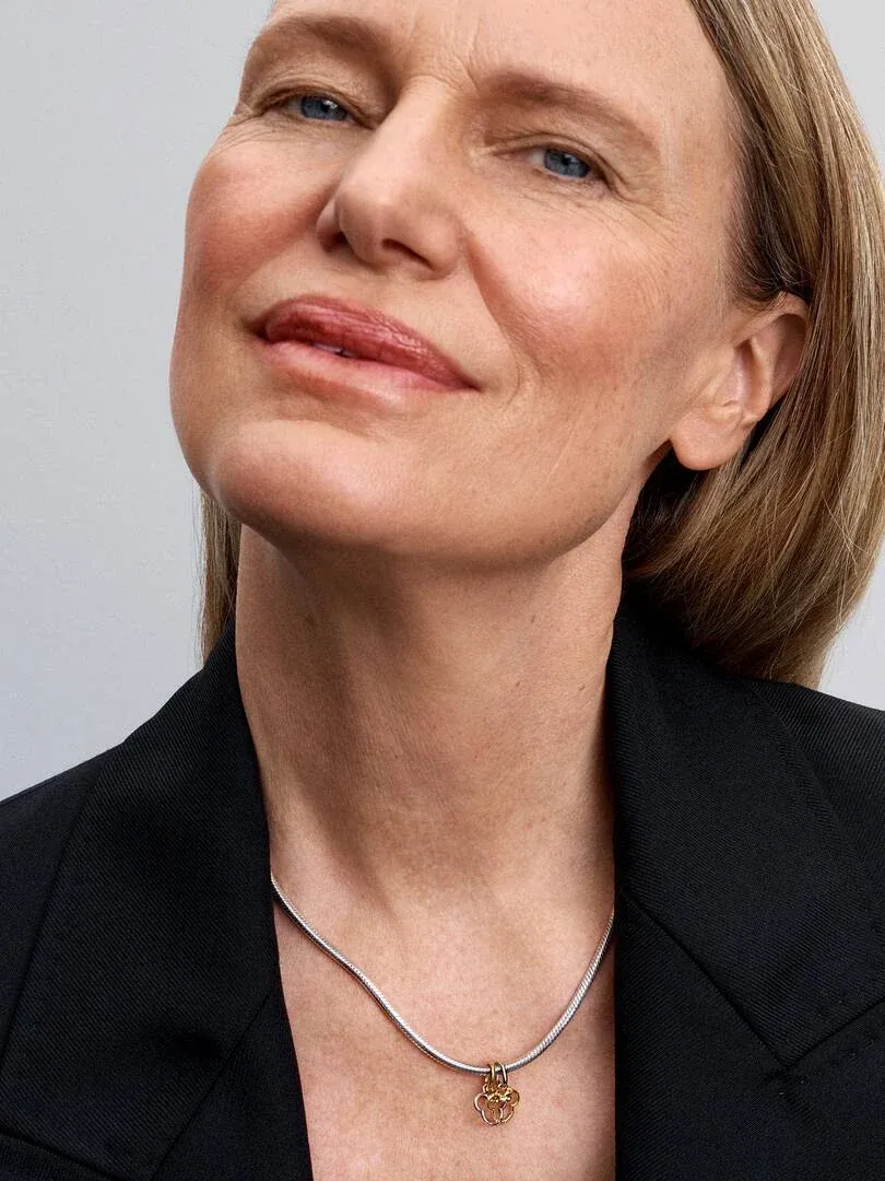 Nahaufnahme des Mickey und Minnie Charms an einer Kette, getragen um den Hals eines Models.