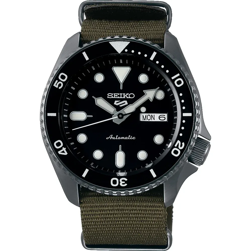 Vista frontal completa del reloj con correa de tela verde oliva y esfera negra, fondo blanco.