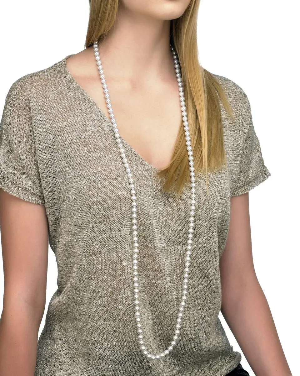 Mannequin portant un long collier de perles sur un t-shirt beige, plan moyen frontal